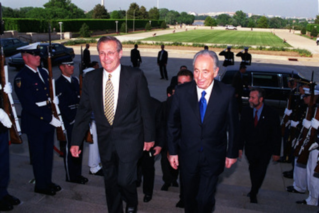 Israeli Foreign Minister Shimon Peres (right) is escorted by Secretary of Defense Donald H. Rumsfeld (left) as he arrives at the Pentagon on May 3, 2001, for a working dinner. Peres and Rumsfeld will discuss a range of regional security issues of interest to both nations. 
