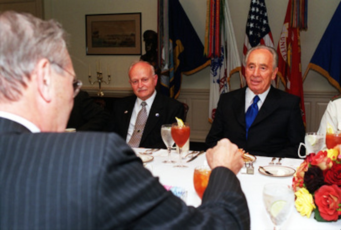 Israeli Foreign Minister Shimon Peres (right) talks to Secretary of Defense Donald H. Rumsfeld (back to camera) at the beginning of a working dinner at the Pentagon on May 3, 2001. Under discussion is a range of regional security issues of interest to both nations. Israeli Ambassador to the United States David Ivry (center) joined Peres and Rumsfeld in the talks. 