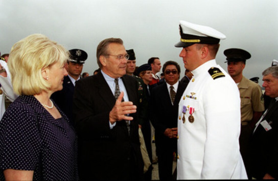 Secretary of Defense Donald H. Rumsfeld shares some of his experiences as a naval aviator with Lt. Shane J. Osborn, USN, as Lt. Osborn's mother Diana (left) looks on. Osborn is the pilot of the EP-3 aircraft which was forced to make an emergency landing April 1, 2001, on Hanian Island, Peoples Republic of China. The 24 member crew were presented awards during the the opening ceremony of the Joint Services Open House at Andrews Air Force Base, MD, May 18, 2001, which drew thousands of spectators. 
