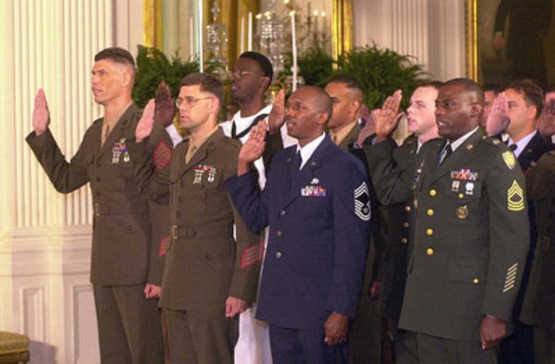 At the White House President George W. Bush hosted a reenlistment ceremony for 100 servicemembers representing each of the Armed Forces on May 23, 2001. Secretary of Defense Donald H. Rumsfeld delivered the opening remarks and Chairman of the Joint Chiefs of Staff Gen. Henry H. Shelton administered the oath of enlistment. President Bush and Defense Secretary Donald Rumsfeld both spoke before the reenlistment ceremony, with Rumsfeld telling the troops their task now is to "protect our country from the unknown, uncertain, unseen and unexpected." In the front row (l-r) are: 1st Sgt. Mark Anthony McCloskey, USMC, Master Sgt. Michael W. Helbig, USMC, Chief Master Sgt. Willie L. Davis, USAF, and Master Sgt. Gregory Johnson, USA. 