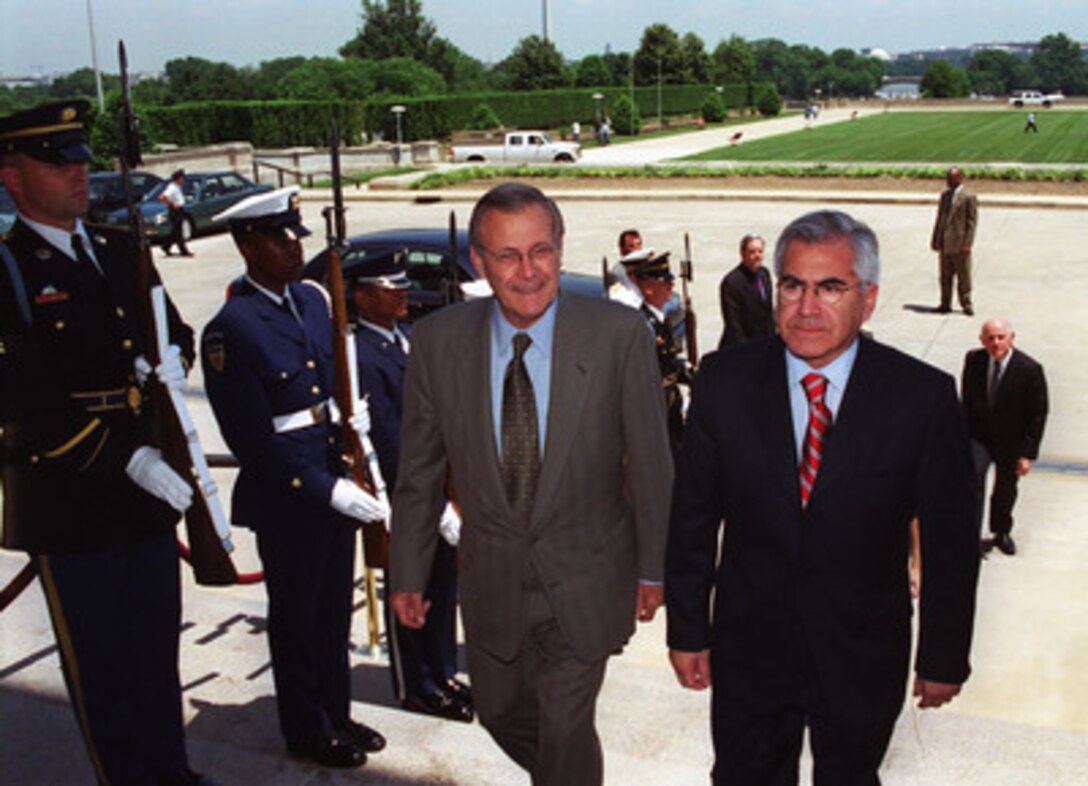 Minister of Defense Mario Fernandez (right), of the Republic of Chile, arrives at the Pentagon, May 24, 2001, where he is greeted and escorted into the building by Secretary of Defense Donald H. Rumsfeld (left). Fernandez, in the United States to deliver the keynote speech for the Seminar on Research and Education in Defense and Security Studies being held at the National Defense University at Ft. McNair, Washington, D. C., took the opportunity to stop by the Department of Defense to meet with Rumsfeld. 