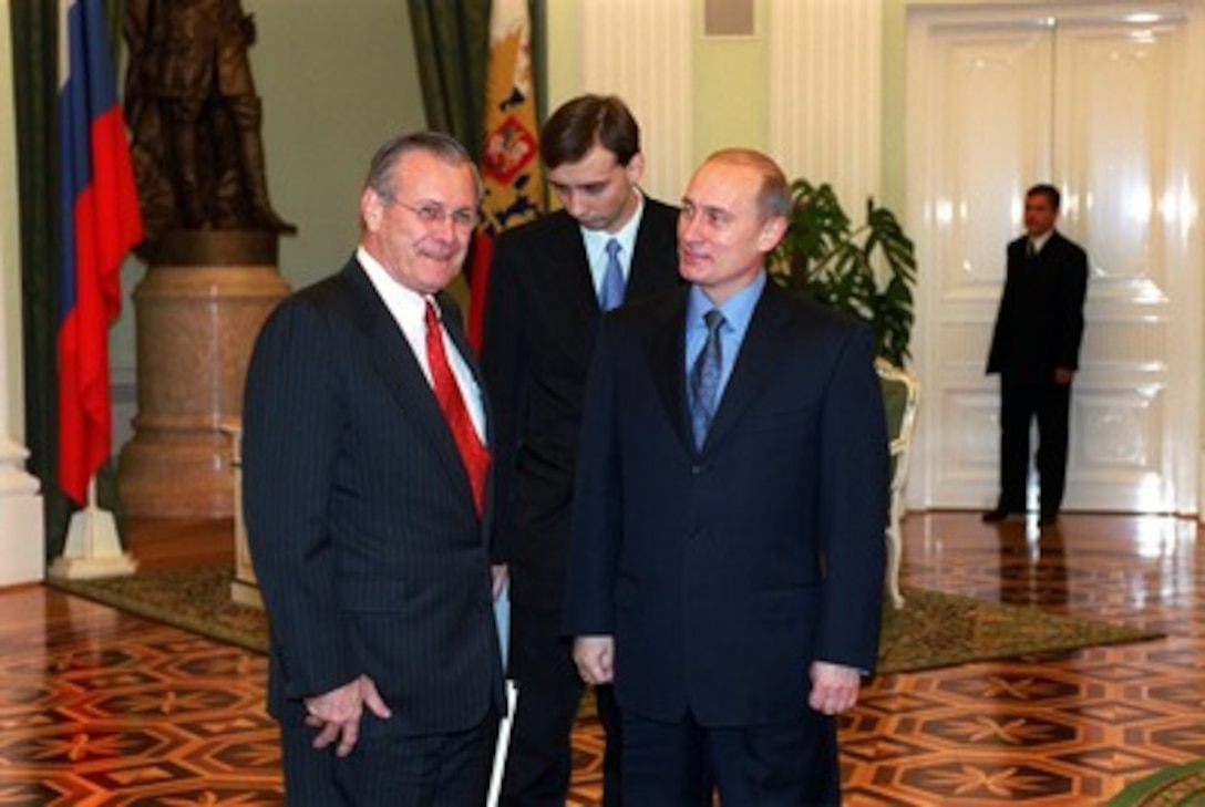 Secretary of Defense Donald H. Rumsfeld (left) and Russian President Vladimir Putin (right) pose for photographers as they meet in the Kremlin on Nov. 3, 2001. Rumsfeld's visit is laying the groundwork for next week's summit meeting in the United States between Putin and George W. Bush. 