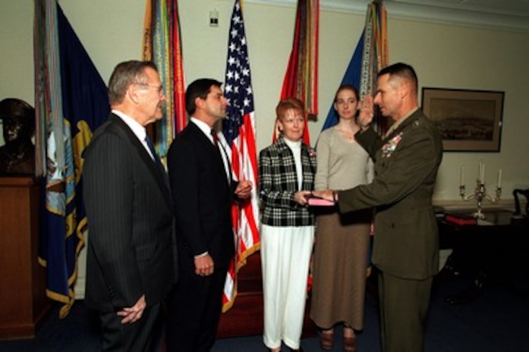 Gen. Peter Pace (right), U.S. Marine Corps, is sworn in as vice chairman of the Joint Chiefs of Staff by William Haynes (2nd from left), as Pace's wife Lynne and daughter Tiffany hold the Bible, in the Pentagon office of Secretary of Defense Donald H. Rumsfeld (left) on Oct. 1, 2001. Haynes is the General Counsel of the Department of Defense. 