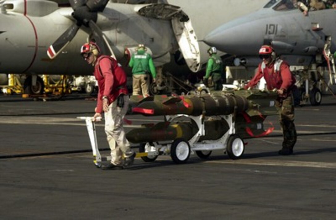 Aviation ordnancemen move laser guided bombs to waiting aircraft on the USS Carl Vinson (CVN 70) in preparation for strikes against al Qaeda terrorist training camps and military installations of the Taliban regime in Afghanistan on Oct. 7, 2001. The carefully targeted actions are designed to disrupt the use of Afghanistan as a base for terrorist operations and to attack the military capability of the Taliban regime. The USS Carl Vinson (CVN 70) is operating in the Arabian Sea as part of Operation Enduring Freedom. 