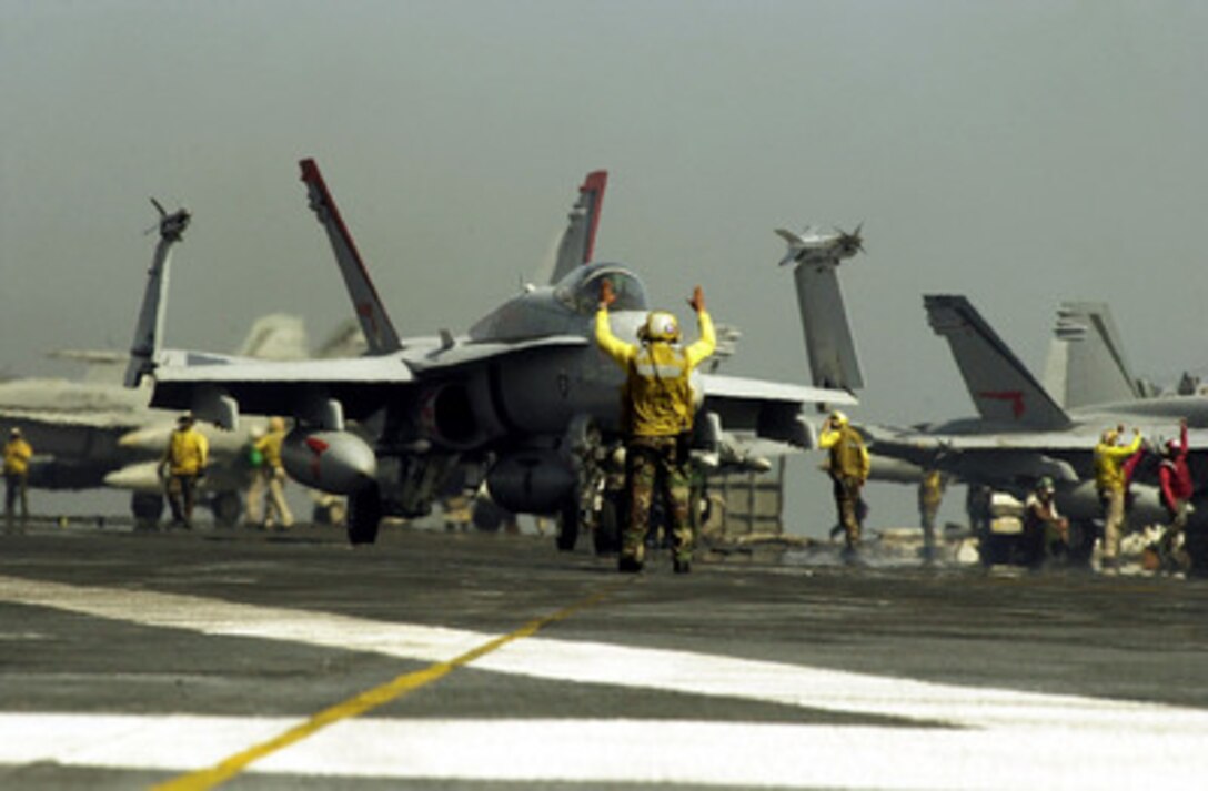 An F/A-18C Hornet is prepared for launch from the aircraft carrier USS Carl Vinson (CVN 70) in a strike against al Qaeda terrorist training camps and military installations of the Taliban regime in Afghanistan on Oct. 7, 2001. The carefully targeted actions are designed to disrupt the use of Afghanistan as a base for terrorist operations and to attack the military capability of the Taliban regime. The USS Carl Vinson (CVN 70) is operating in the Arabian Sea as part of Operation Enduring Freedom. 