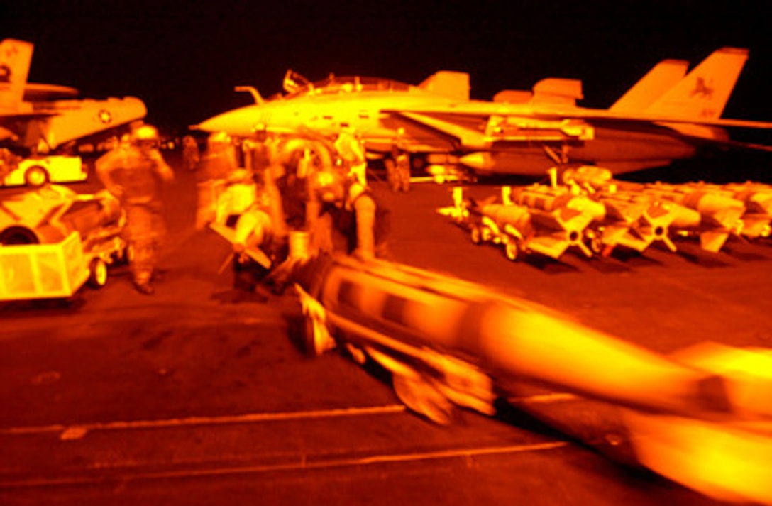 Aviation ordnancemen move a 1,000 pound bomb onto the flight deck of the aircraft carrier USS Carl Vinson (CVN 70) in preparation for strikes against al Qaeda terrorist training camps and military installations of the Taliban regime in Afghanistan on Oct. 7, 2001. The carefully targeted actions are designed to disrupt the use of Afghanistan as a base for terrorist operations and to attack the military capability of the Taliban regime. The USS Carl Vinson (CVN 70) is operating in the Arabian Sea as part of Operation Enduring Freedom. 