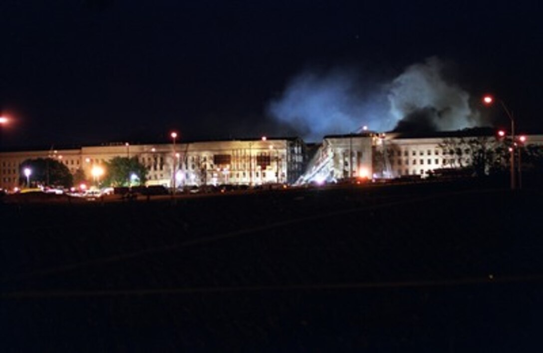 Fire fighters battle stubborn fires through the night at the Pentagon on Sept. 11, 2001. The fire was caused when a hijacked American Airlines flight slammed into the building earlier in the day. The terrorist attack caused extensive damage to the west face of the building and followed similar attacks on the twin towers of the World Trade Center in New York City. 