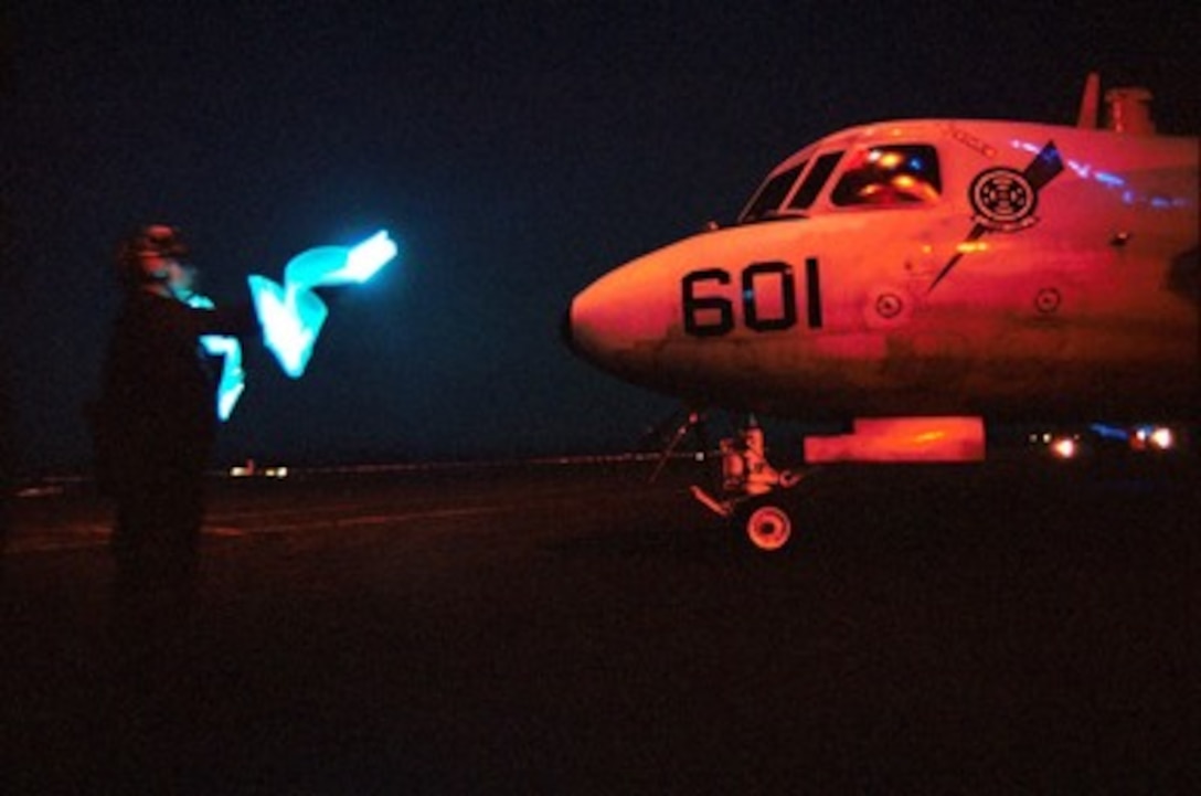 A plane captain uses lighted wands to direct the pilot of an E-2C Hawkeye on board the USS Enterprise (CVN 65) on Oct. 7, 2001, during Operation Enduring Freedom. The Enterprise is launching aircraft for missions against al Qaeda terrorist training camps and military installations of the Taliban regime in Afghanistan. The carefully targeted actions are designed to disrupt the use of Afghanistan as a base for terrorist operations and to attack the military capability of the Taliban regime. 