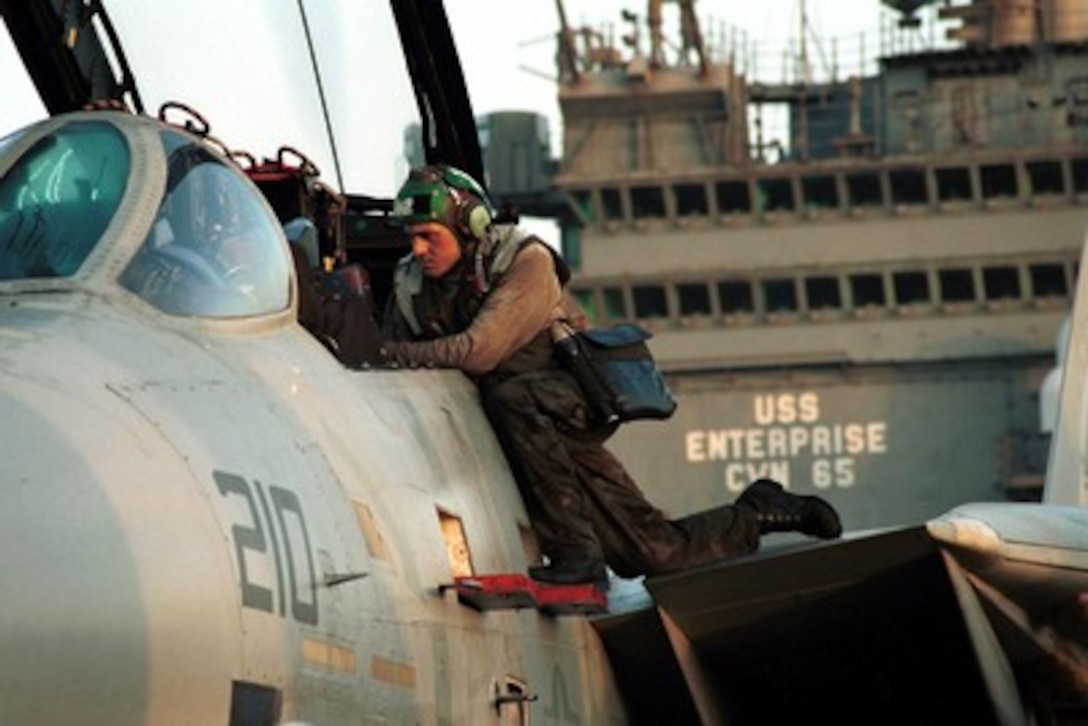 A crewmember readies an F-14A Tomcat for upcoming flight operations in support of Operation Enduring Freedom on the flight deck of the USS Enterprise (CVN 65) on Oct. 7, 2001. Aircraft are being readied for strike missions against al Qaeda terrorist training camps and military installations of the Taliban regime in Afghanistan. The carefully targeted actions are designed to disrupt the use of Afghanistan as a base for terrorist operations and to attack the military capability of the Taliban regime. 