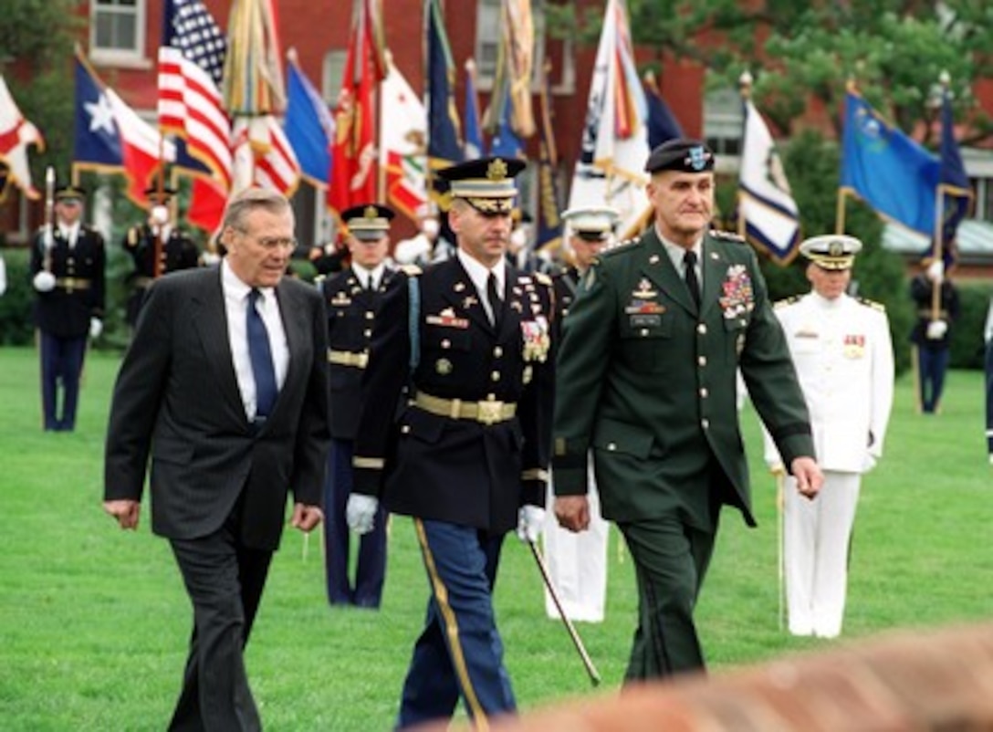 Commander of Troops Col. James F. Laufenburg (center), U.S. Army, escorts Secretary of Defense Donald H. Rumsfeld (left) and retiring Chairman of the Joint Chiefs of Staff Gen. Henry H. Shelton (right), U.S. Army, after they inspected the troops at a ceremony at Fort Myer, Va., on Oct. 2, 2001. Laufenburg is the commander 3rd United States Infantry (The Old Guard). 