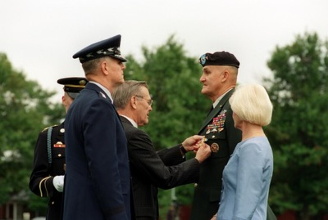 Secretary of Defense Donald H. Rumsfeld awards the Defense Distinguished Service Medal to retiring Chairman of the Joint Chiefs of Staff Gen. Henry H. Shelton during his retirement ceremony at Fort Myer, Va., on Oct. 2, 2001. Shelton's successor Gen. Richard B. Myers, U.S. Air Force, (left), and Shelton's wife Carolyn (right) watch Rumsfeld pin on the medal. 