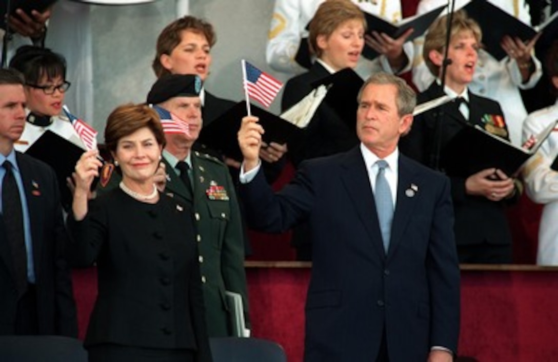 President George W. Bush and first lady Laura Bush wave the flag as the choir sings "God Bless America" during a memorial service at the Pentagon on Oct. 11, 2001, in honor of those who perished in the terrorist attack on the building. President Bush, Secretary of Defense Donald H. Rumsfeld and Chairman of the Joint Chiefs of Staff Gen. Richard B. Myers, U.S. Air Force, eulogized the 184 persons killed when a terrorist hijacked airliner was purposely crashed into the southwest face of the building on Sept. 11, 2001. 