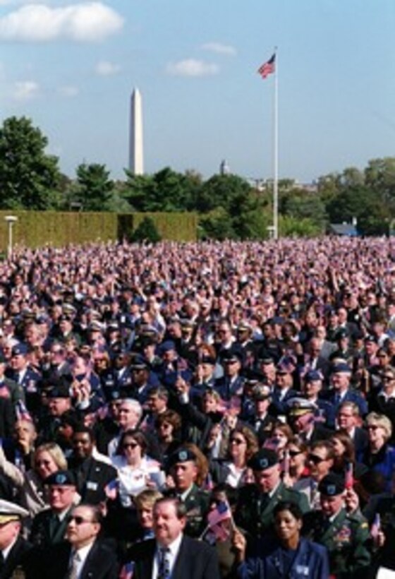 The audience on the Pentagon River Parade Field wave their flags as the choir sings "God Bless America" during a memorial service at the Pentagon on Oct. 11, 2001, in honor of those who perished in the terrorist attack on the building one month earlier. President George W. Bush, Rumsfeld and Chairman of the Joint Chiefs of Staff Gen. Richard B. Myers, U.S. Air Force, eulogized the 184 persons killed when a terrorist hijacked airliner was purposely crashed into the southwest face of the building on Sept. 11, 2001. 