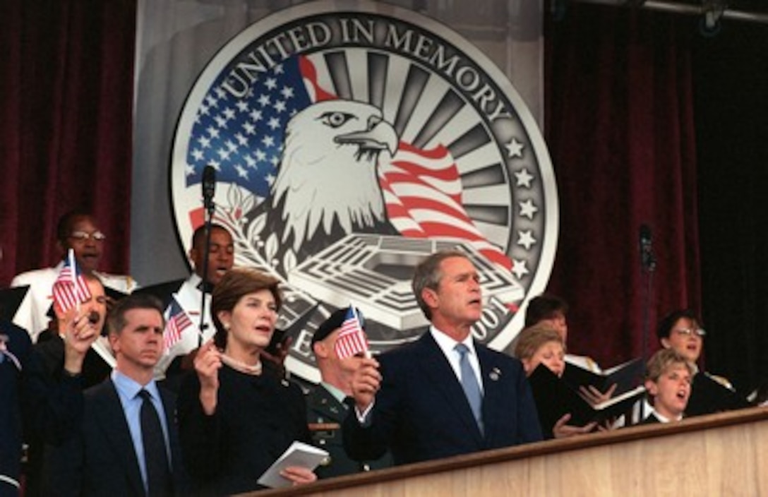 President George W. Bush and first lady Laura Bush wave the flag and sing "God Bless America" during a memorial service at the Pentagon on Oct. 11, 2001, in honor of those who perished in the terrorist attack on the building. President Bush, Secretary of Defense Donald H. Rumsfeld and Chairman of the Joint Chiefs of Staff Gen. Richard B. Myers, U.S. Air Force, eulogized the 184 persons killed when a terrorist hijacked airliner was purposely crashed into the southwest face of the building on Sept. 11, 2001. 