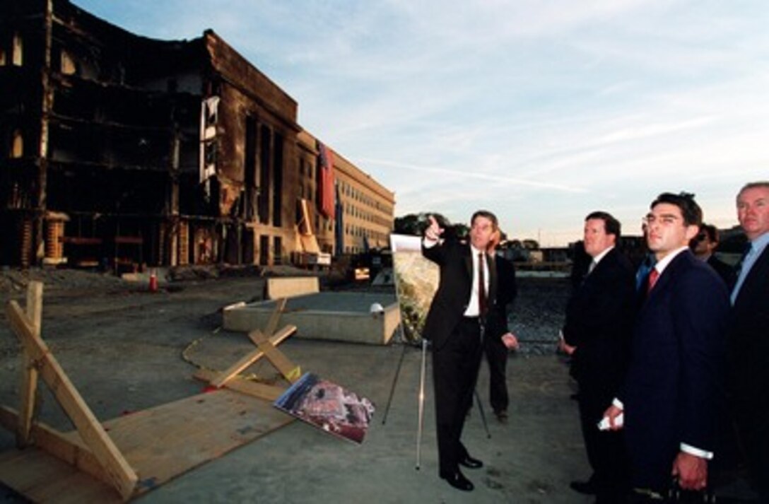 NATO Secretary General Lord George Robertson (center) is given a briefing at the Pentagon crash site by Michael Sullivan (left), deputy program manager of the Pentagon Renovation Office, on Oct. 10, 2001. The damage was caused when a hijacked American Airlines flight slammed into the building on Sept. 11th. The terrorist attack caused extensive damage to the west face of the building and followed similar attacks on the twin towers of the World Trade Center in New York City. 