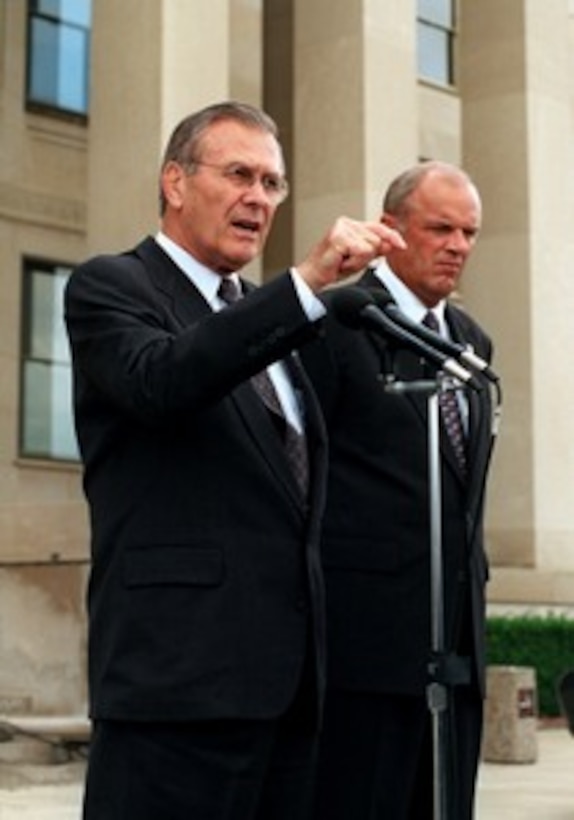 Secretary of Defense Donald H. Rumsfeld (left), and Secretary of the Army Thomas E. White (right), take questions from reporters gathered outside the Pentagon Mall Entrance on Oct. 11, 2001. Rumsfeld and White briefed reporters on homeland defense and the on-going air campaign being directed against the al Qaeda terrorist organization and the military capability of Taliban regime in Afghanistan. 