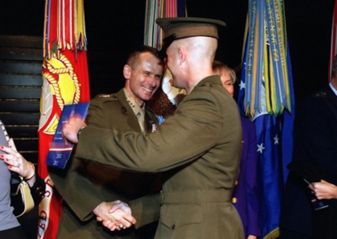 Gen. Peter Pace, U.S. Marine Corps, vice chairman of the Joint Chiefs of Staff, is congratulated by his son Marine 2nd Lt. Pete Pace at a welcoming ceremony for the new vice chairman held at Fort Myer, Va. on Oct. 15, 2001. Secretary of Defense Donald H. Rumsfeld and President George W. Bush were on hand to formally welcome Chairman of the Joint Chiefs of Staff Gen. Richard B. Myers, U.S. Air Force, and Pace to their new posts at the Pentagon. Gen. Pace becomes the first Marine Corps officer to hold one of the two top uniformed positions in the DoD. 