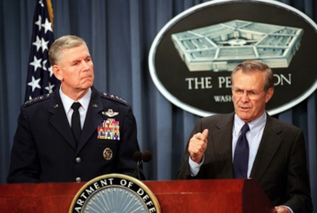 Secretary of Defense Donald H. Rumsfeld (right) explains to reporters that there is no single coalition of nations in this war on terrorism during a press briefing at the Pentagon on Oct. 18, 2001, Chairman of the Joint Chiefs of Staff Gen. Richard B. Myers (left), U.S. Air Force, briefed reporters on some of the previous day's operational details. 