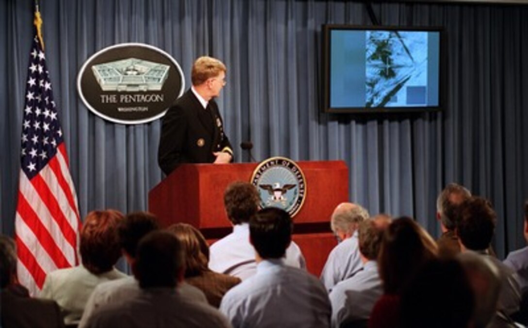 Rear Adm. John D. Stufflebeem, U.S. Navy, shows reporters a video clip during a Pentagon press briefing on Oct. 17, 2001. The armament delivery recording, more commonly known as gun camera footage, is from the targeting system of an U.S. aircraft as it attacks a target in Afghanistan. Stufflebeem is the deputy director of Operations for Current Readiness and Capabilities, Joint Staff. 