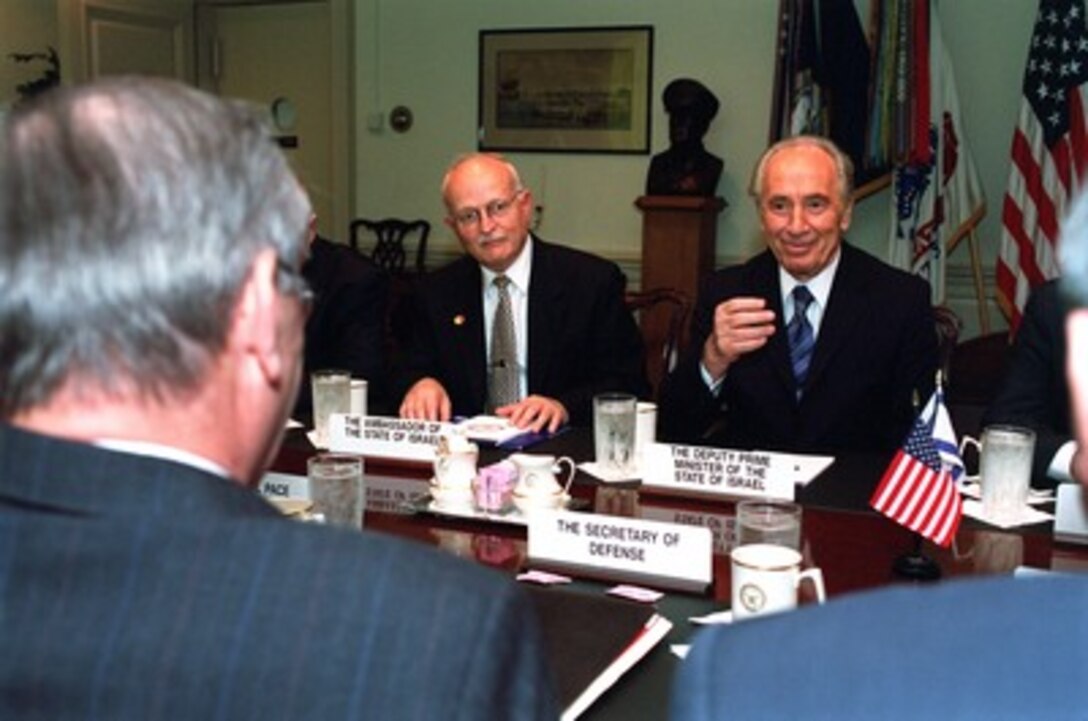 Israeli Deputy Prime Minister Shimon Peres (right) meets with Secretary of Defense Donald H. Rumsfeld (foreground) in the Pentagon on Oct. 22, 2001. Israel's Ambassador to the United States David Ivry (center) joined Peres and Rumsfeld in the talks. 