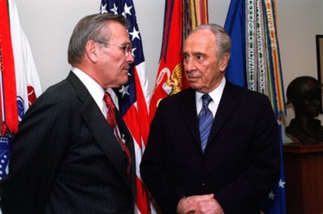 Secretary of Defense Donald H. Rumsfeld (left) and Israeli Deputy Prime Minister Shimon Peres share some private thoughts before sitting down to formal discussions in the Pentagon on Oct. 22, 2001. 