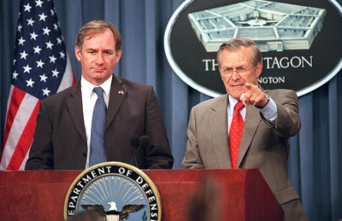 Secretary of Defense Donald H. Rumsfeld (right) acknowledges a reporter during a joint press conference in the Pentagon with Secretary of State for Defence Geoffrey Hoon (left), of the United Kingdom, on Oct. 30, 2001. The two defense leaders met earlier to discuss the progress of the ongoing military campaign against the forces of al Qaeda and their Taliban hosts in Afghanistan. 