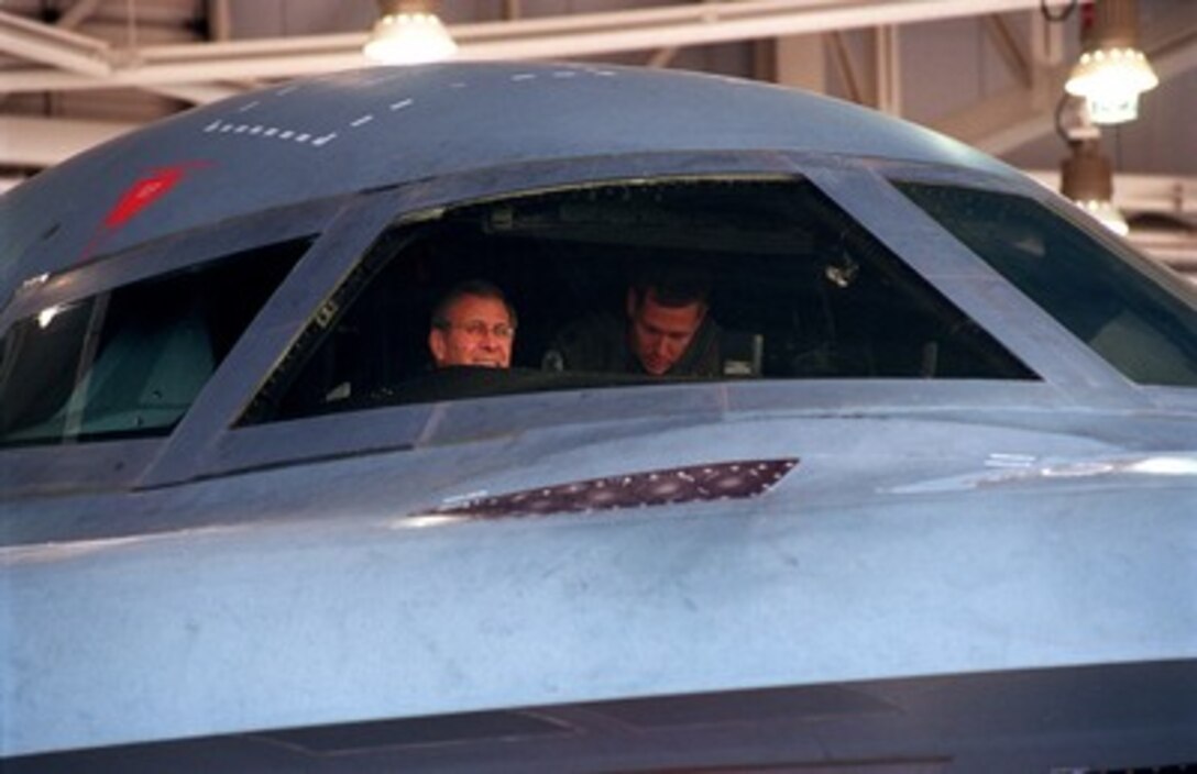 Secretary of Defense Donald H. Rumsfeld (left) peers out the windshield from the mission commander's seat of a U.S. Air Force B-2 Spirit bomber at Whiteman Air Force Base, Mo., on Oct. 19, 2001. Rumsfeld is receiving a cockpit orientation from a pilot of the 509th Bomb Wing. Planes from the 509th have flown missions over Afghanistan during Operation Enduring Freedom. 