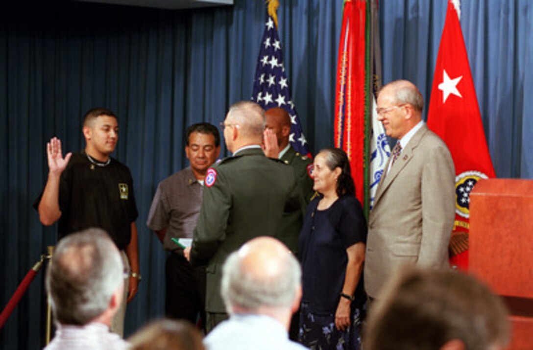 Pvt. Rodrigo Vasquez (left) is sworn into the U.S. Army by Maj. Gen. Dennis Cavin as Vasquez's parents (center) and Secretary of the Army Thomas White (far right) watch during a ceremony in the Pentagon on Sept. 4, 2001. Vasquez's enlistment was part of a press briefing conducted by Cavin and White on the Army meeting its recruiting goals. Cavin is the commanding general, U.S. Army Recruiting Command. 