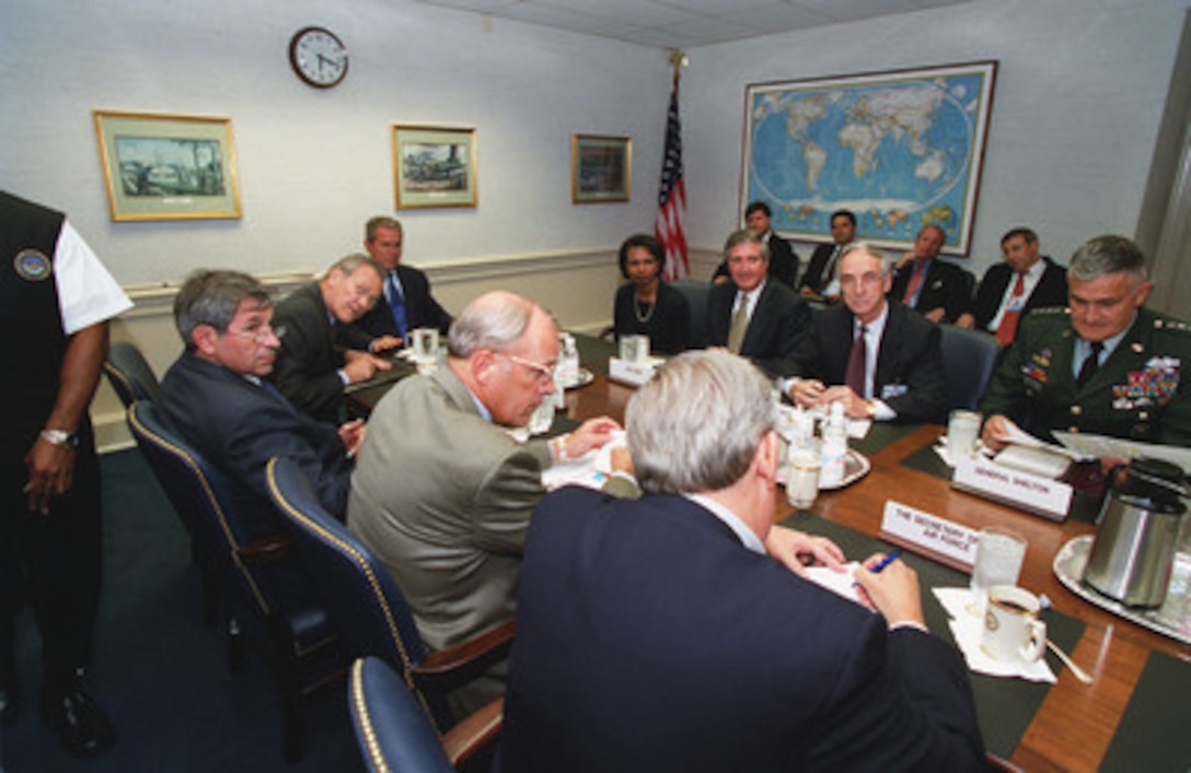 Secretary of Defense Donald H. Rumsfeld (second from left) introduces his staff members to President George W. Bush at their Pentagon meeting on Sept. 12, 2001. Counterclockwise from Rumsfeld is Deputy Secretary of Defense Paul Wolfowitz, Secretary of the Army Thomas E. White, Secretary of the Air Force James Roche, Chairman Joint Chiefs of Staff Gen. Henry H. Shelton, U.S. Army, Secretary of the Navy Gordon England, White House Chief of Staff Andrew Card, and National Security Advisor Condoleeza Rice. Bush inspected the site of the terrorist attack on the building to thank the men and women who assisted in containing the fires and rescuing victims. 