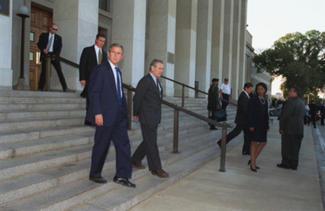 President George W. Bush is escorted from the Pentagon by Secretary of Defense Donald H. Rumsfeld on Sept. 12, 2001. Bush inspected the site of the terrorist attack on the building to thank the men and women who assisted in containing the fires and rescuing victims. Bush later met with Rumsfeld and members of his staff. 