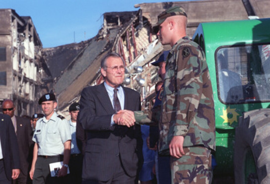 Secretary of Defense Donald H. Rumsfeld thanks one of the many Military District of Washington soldiers working at the site of a terrorist attack on the Pentagon. During a Sept. 12, 2001, visit to the scene of the disaster Rumsfeld and President George W. Bush toured the crash site and thanked the fire fighters, police officers, search and rescue personnel, FBI investigators and other professionals at the disaster site. 