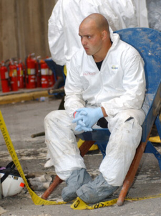 A worker at the crash site takes a break as he waits his turn to help recovery efforts at the Pentagon on Sept. 14, 2001. The Pentagon was damaged when the hijacked American Airlines flight slammed into the building on Sept. 11th. The terrorist attack caused extensive damage to the west face of the building and followed similar attacks on the twin towers of the World Trade Center in New York City. 