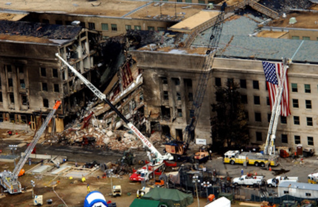 FBI agents, fire fighters, rescue workers and engineers work at the Pentagon crash site on Sept. 14, 2001, where a hijacked American Airlines flight slammed into the building on Sept. 11. The terrorist attack caused extensive damage to the west face of the building and followed similar attacks on the twin towers of the World Trade Center in New York City. 