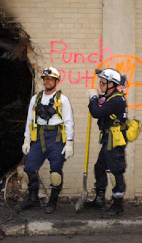Rescue workers take a breath of fresh air near an entrance to the crash site at the Pentagon on Sept. 14, 2001. Damage to the Pentagon was caused when the hijacked American Airlines flight slammed into the building on Sept. 11th. The terrorist attack caused extensive damage to the west face of the building and followed similar attacks on the twin towers of the World Trade Center in New York City. 