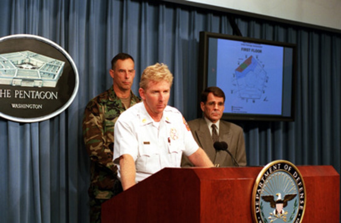 Assistant Fire Chief James H. Schwartz, of the Arlington County Fire Dept., answers questions on the status of the containment of fire in the Pentagon during a joint press briefing on Sept. 14, 2001. The fire was caused when a hijacked American Airlines flight slammed into the building on Sept. 11th. The terrorist attack caused extensive damage to the west face of the building and followed similar attacks on the twin towers of the World Trade Center in New York City. Maj. Gen. James Jackson, commanding general of the Military District of Washington, and Director of the Federal Facilities Division John F. Irby joined Schwartz in briefing the initial damage assessment of the Pentagon. 