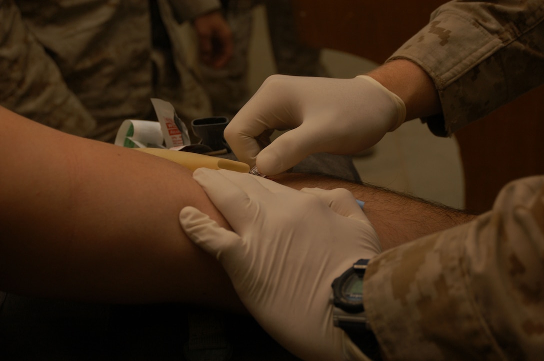 AL ASAD, Iraq--A Marine inserts an IV needle into a fellow Marine.  This training is necessary in the event a corpsman is tending to other patients in a combat situation.   Close to 30 sailors make up the Marine Wing Support Squadrons 271 medical unit providing care for more than 1,200 Marines and sailors here.  They utilize radiography equipment and have the ability to perform laboratory tests, issue medications, and provide the majority of preventive medicine for the forward operating bases of the 2nd Marine Aircraft Wing.