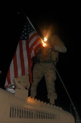 CAMP BLUE DIAMOND, RAMADI, Iraq (May 7, 2005) - Lance Cpl. Clayton B. Turner, turret gunner and native of Sandy Mush, N.C., attaches an American flag to the antenna of his humvee during a brief pause at Camp Blue Diamond. Turner and the Marines of 2nd Low Altitude Air Defense, Bravo Co., 2nd Platoon have been providing security for Department of Defense contracted supply trucks for the past three months.