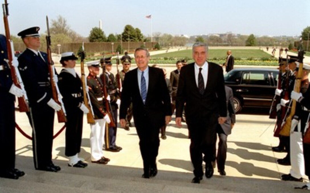 Secretary of Defense Donald H. Rumsfeld (left) escorts Greek Minister of National Defense Yiannos Papantoniou (right) through a joint services honor cordon and into the Pentagon on April 8, 2002. The two defense leaders will meet to discuss a range of bilateral security issues. 