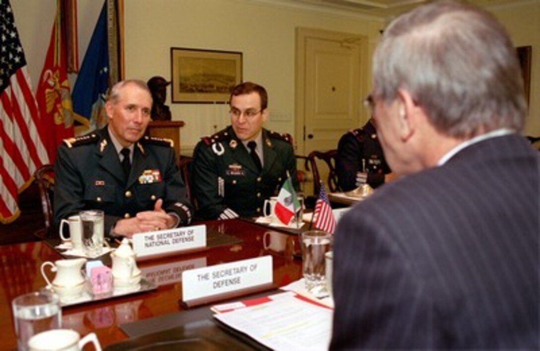 Mexican Secretary of National Defense Gen. Gerardo Clemente Ricardo Vega Garcia (left) meets with Secretary of Defense Donald H. Rumsfeld (foreground) in the Pentagon on April 11, 2002. The talks centered on a number of bilateral, regional security issues of interest to both nations. Mexican Army Col. G. Wolburg (center) joined Vega and Rumsfeld for the talks and provided translations for Vega. 