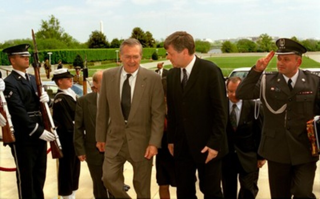 Secretary of Defense Donald H. Rumsfeld (left) escorts Polish Minister of Defense Jerzy Szmajdzinski (center) through an honor cordon and into the Pentagon on April 23, 2002. The two defense leaders will meet to discuss a broad range of bilateral and NATO-related security issues. Saluting at the right is Col. Janusz Bojarski, defense attachÇ at the Polish Embassy. 