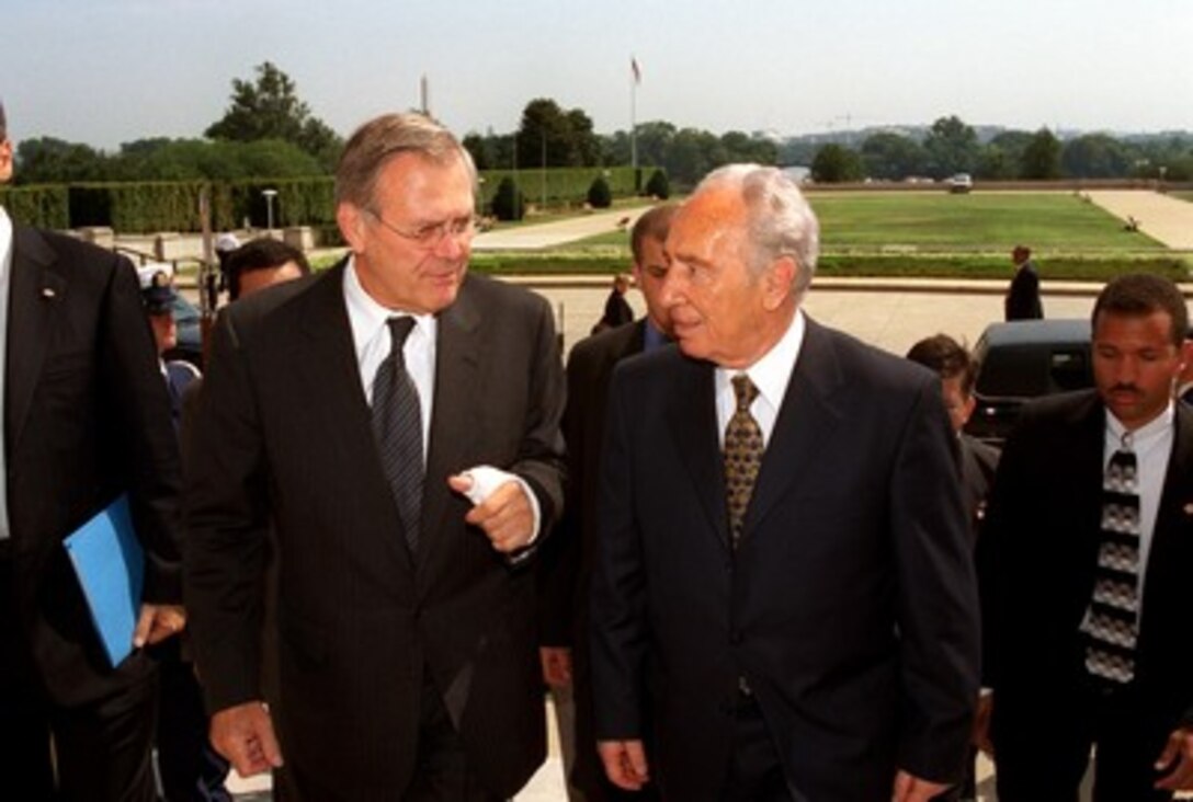 Secretary of Defense Donald H. Rumsfeld (left) escorts Israeli Minister of Foreign Affairs Shimon Peres into the Pentagon on Aug. 1, 2002. The two men will meet to discuss a range of issues of concern to both nations. 