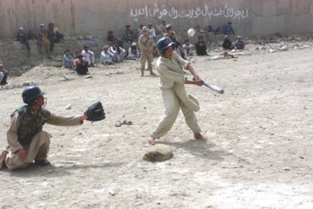 Soldiers and Afghans look on as the two teams of the Afghan little league, formed by U.S. Civil Affairs and Special Operations Forces soldiers in Orgun, Afghanistan, square off in the fourth game of their ten-game season. 