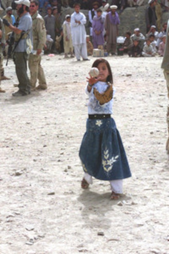 Hatira, a seven-year-old Orgun villager, learns to play a game of catch during the Afghan little league's fourth game. 