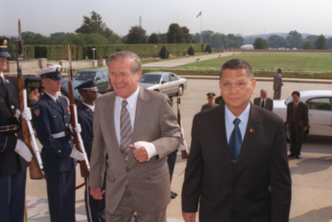 Secretary of Defense Donald H. Rumsfeld (left) escorts Minister of National Defense Angelo Reyes, of the Republic of the Philippines, into the Pentagon on Aug. 12, 2002. The two defense leaders will hold discussions on a broad range of security topics, including the war on terrorism. 
