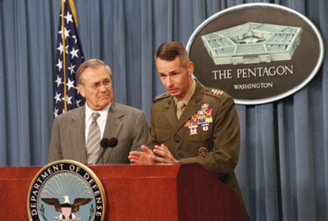 Secretary of Defense Donald Rumsfeld looks on as Vice Chairman of the Joint Chiefs of Staff Gen. Peter Pace, U.S. Marine Corps, answers a reporter's question concerning the recently completed joint service training experiment called Millennium Challenge during tan Aug. 20, 2002, Pentagon press briefing. 