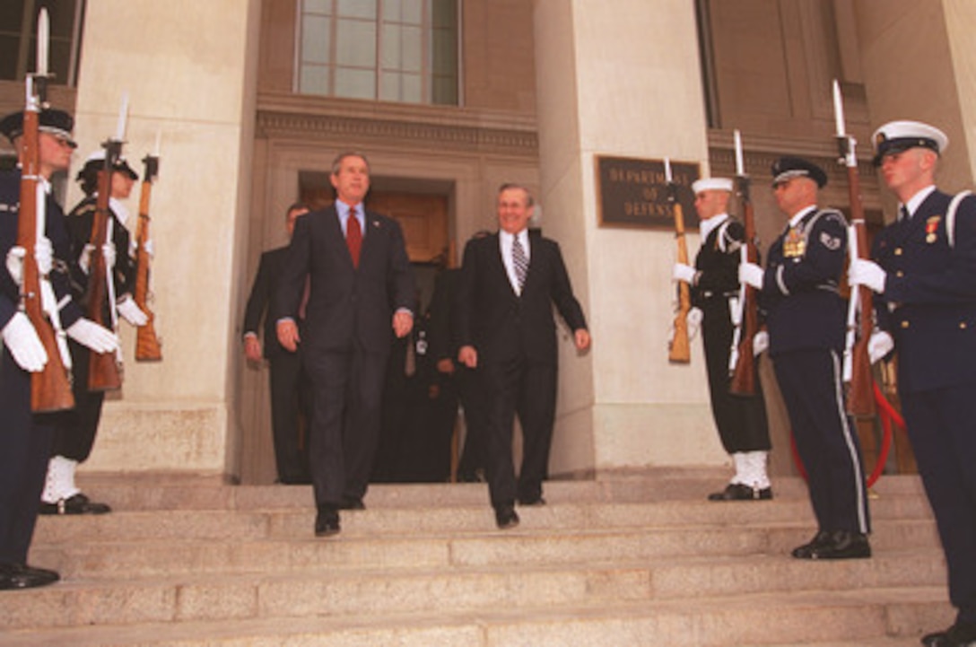 Secretary of Defense Donald H. Rumsfeld escorts President George W. Bush through an honor cordon as he leaves the Pentagon on Dec. 2, 2002. Bush was at the Pentagon to sign the Department of Defense Authorization Bill and to speak to military and DoD civilian personnel. 