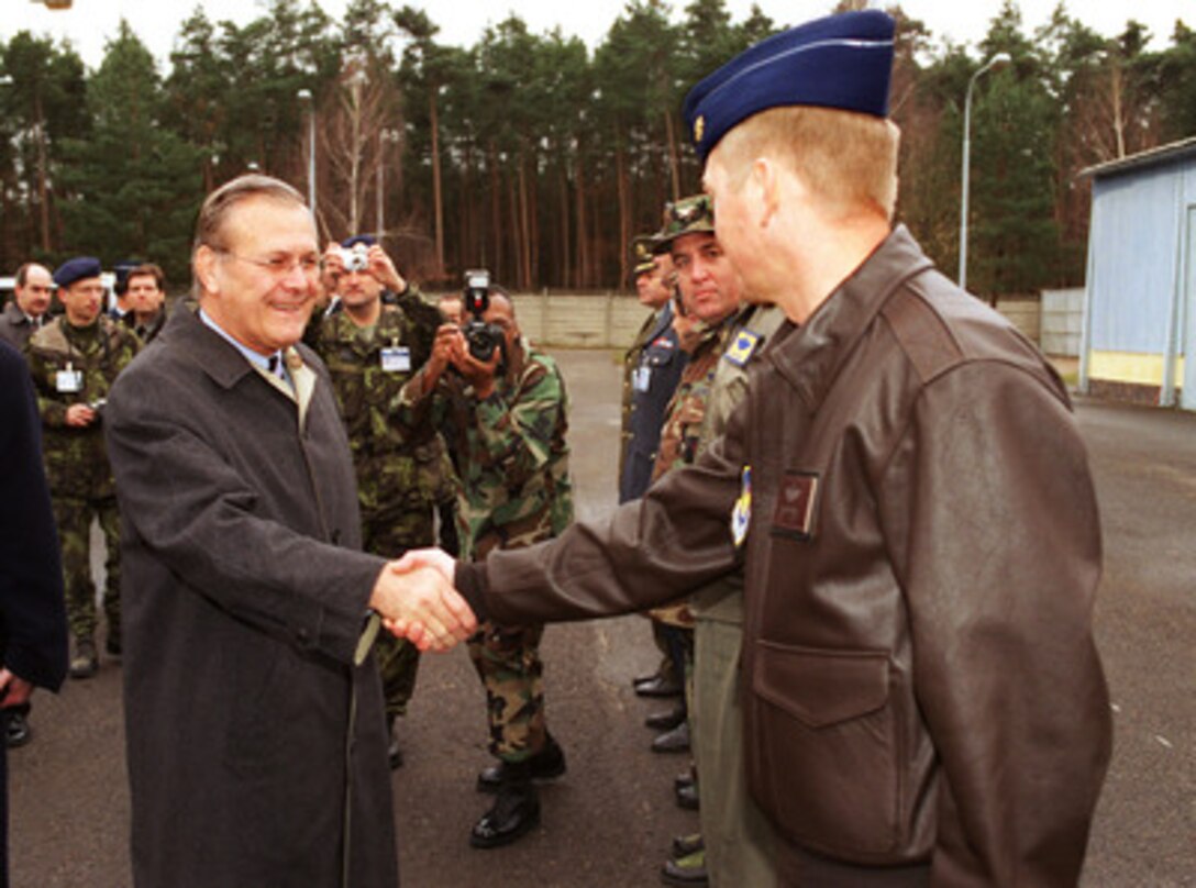Secretary of Defense Donald H. Rumsfeld (left) greets one of the U.S. Air Force officers on temporary duty at the National Command Center Stara Boleslav located near Prague, Czech Republic, on Nov. 20, 2002. The U.S. Air Force is providing fighter aircraft and air intercept ground controllers to help ensure the safety of the airspace around Prague for the upcoming NATO Summit meeting. 