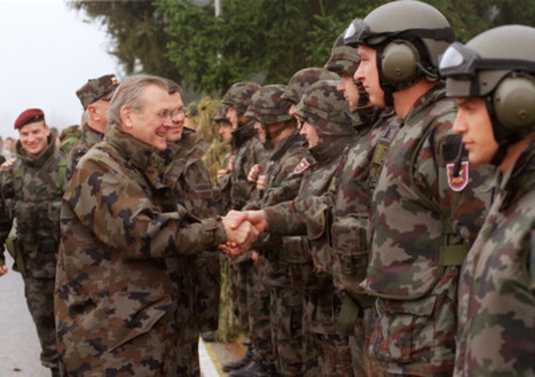 Secretary of Defense Donald H. Rumsfeld and Minister of Defense Anton Grizold greet troops of the Slovenian Army's 10th Motorized Battalion while visiting Ljubljana Barracks, Slovenia, on Nov. 23, 2002. Rumsfeld and Grizold watched a training exercise where the Slovenian troops conducted a hostage rescue from a building taken over by militants. Elements of the 10th Motorized Battalion will soon deploy to the U.S. controlled sector of Bosnia, as part of the multinational peacekeeping forces there. 