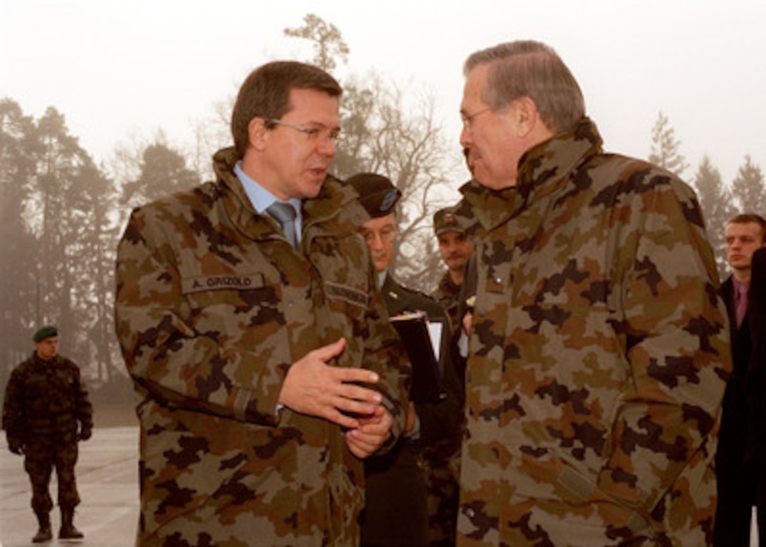 Secretary of Defense Donald H. Rumsfeld (right) talks with Slovenian Defense Minister Anton Grizold (left) as they tour a military base near Ljubljana, Slovenia, on Nov. 23, 2002. Slovenia was one of the seven nations nominated for NATO membership at the NATO Summit, held in Prague, Czech Republic. Rumsfeld is in Slovenia to congratulate the leadership of the country and pledge U.S. assistance in helping to ensure that the Slovenian military can fulfill the requirements for full NATO membership. 