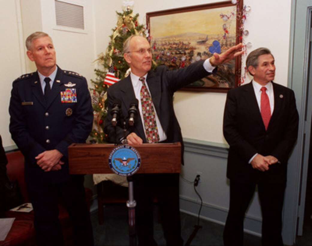 Idaho Senator Larry Craig points out the Pentagon window towards the large holiday tree donated to the Department of Defense by the people of Idaho. Also at the lectern are the hosts for the Dec. 13, 2002, ceremony, Deputy Secretary of Defense Paul Wolfowitz (right) and Chairman of the Joint Chiefs of Staff Gen. Richard B. Myers, U.S. Air Force (left). 